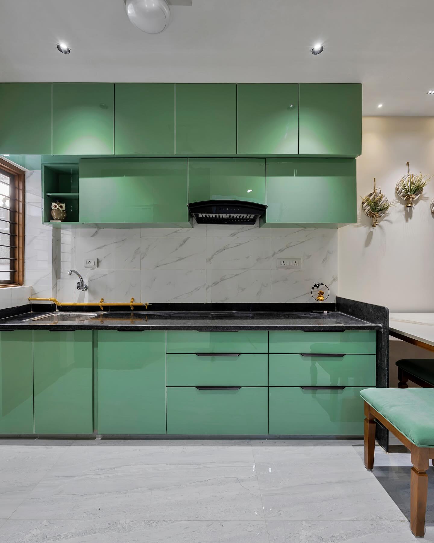 Green modular kitchen with marble backsplash
