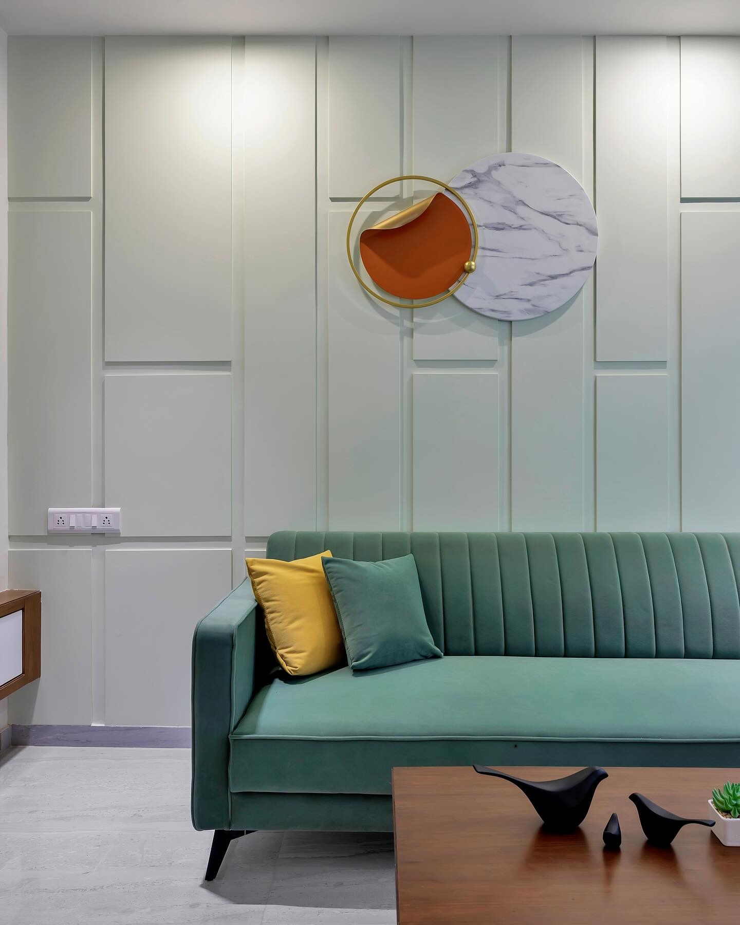 Sage sofa with sculptural metal wall art